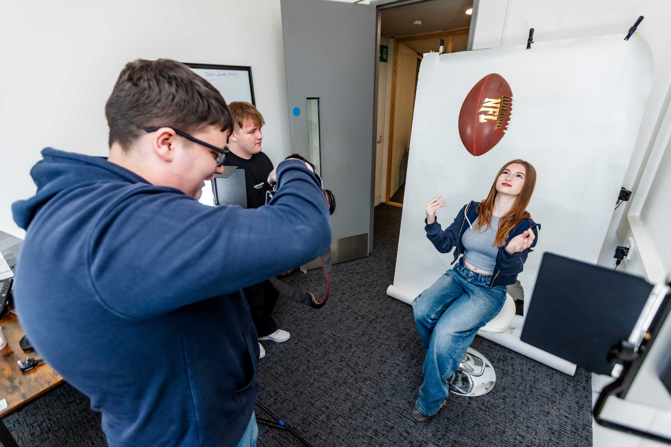 Sports Media Production students during a photoshoot with an NFL ball